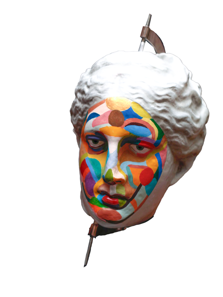 Pion issu du jeu la Chose Publique, réalisé par Camille Leherper, animateur à l'Espace Jemmapes. Le pion une tête portant un masque multicolore, avec un oeil attristé